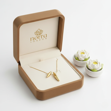 Dual Drop Pendant Gold Plated in an open brown jewelry box with 'Nora London' branding, on a light gray background.