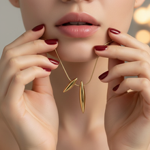Close-up of a woman wearing Dual Drop Pendant with blurred background