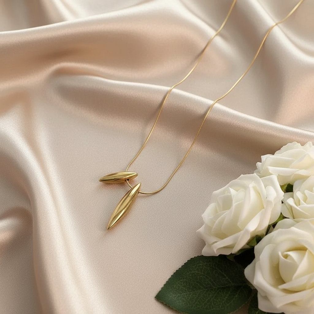 Gold Plated Dual Drop pendant on beige fabric with white roses
