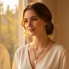 Woman wearing a Gold Plated Iconic Toggle Pendant in a warm, softly lit room.