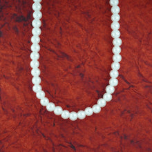 Pearl necklace on a red textured background