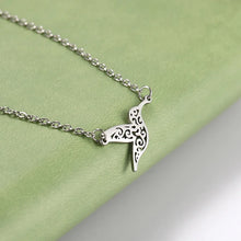 Silver Plated hummingbird necklace on a green fabric background
